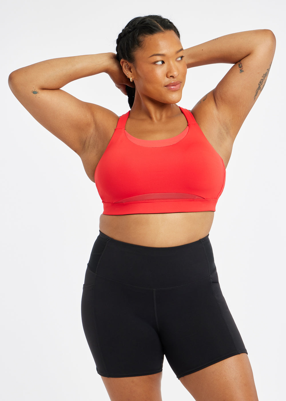 Woman wearing red orange band and cup sports bra, alternate front view