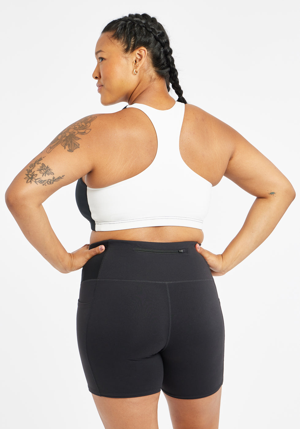Woman wearing black and white paneled sports bra, back view