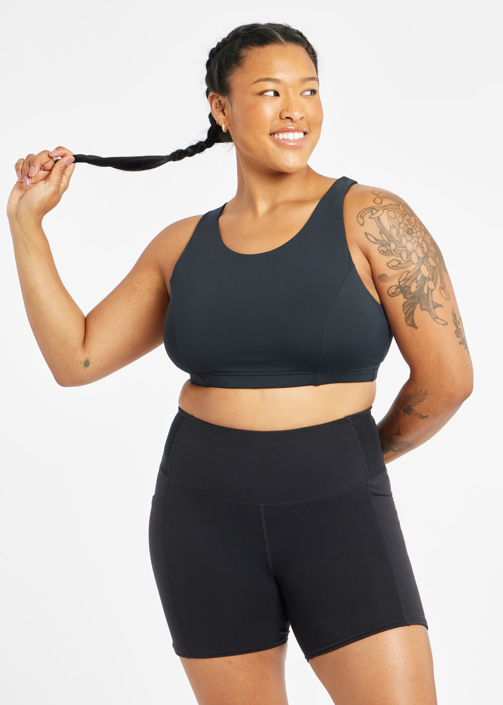 Woman wearing black sports bra in size 12, alternate front view