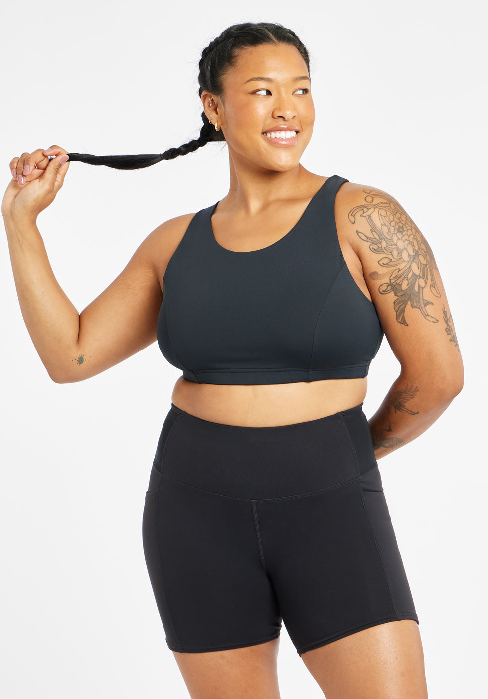 Woman wearing black sports bra in size 12, alternate front view