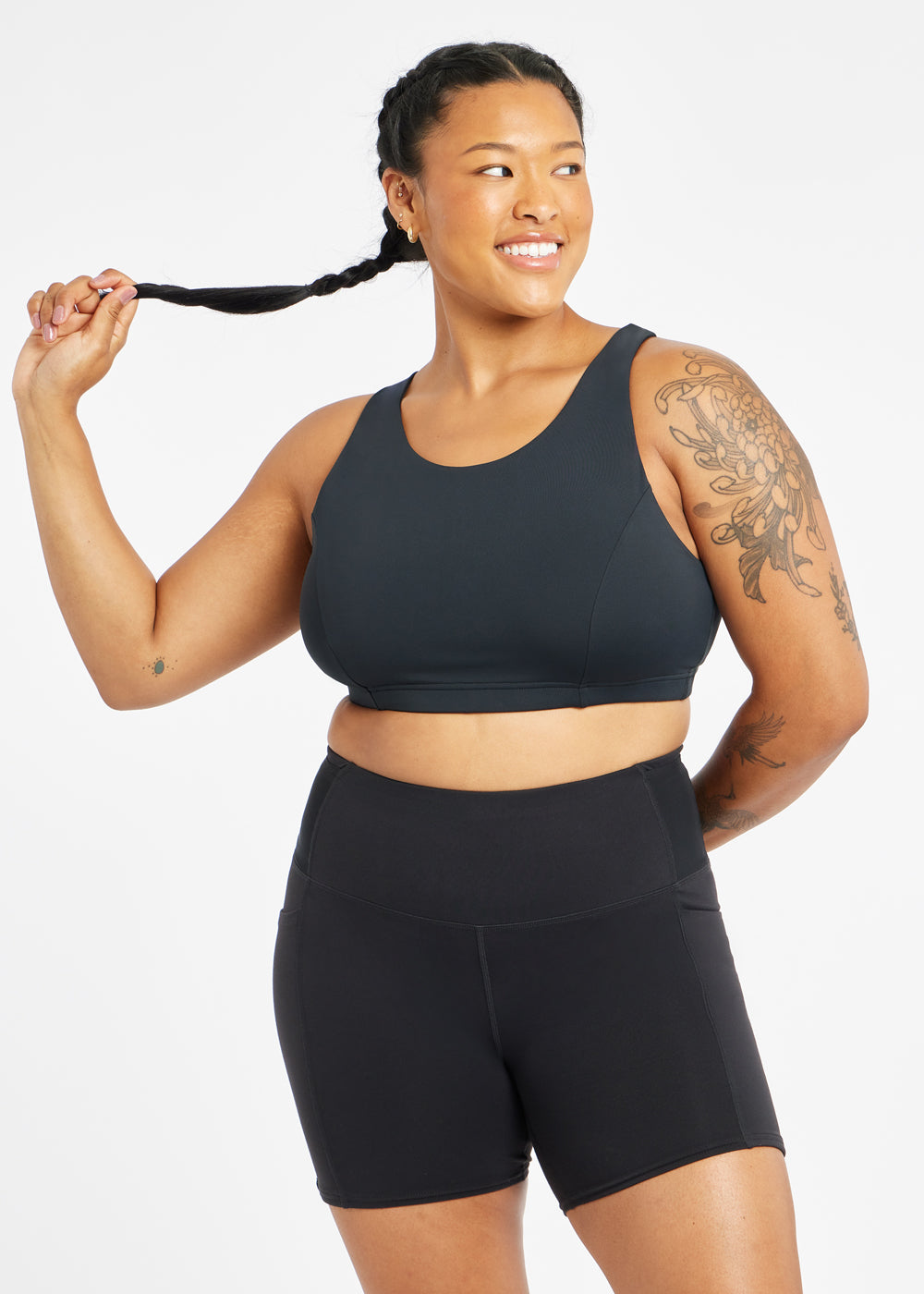 Woman wearing black sports bra in size 12, alternate front view