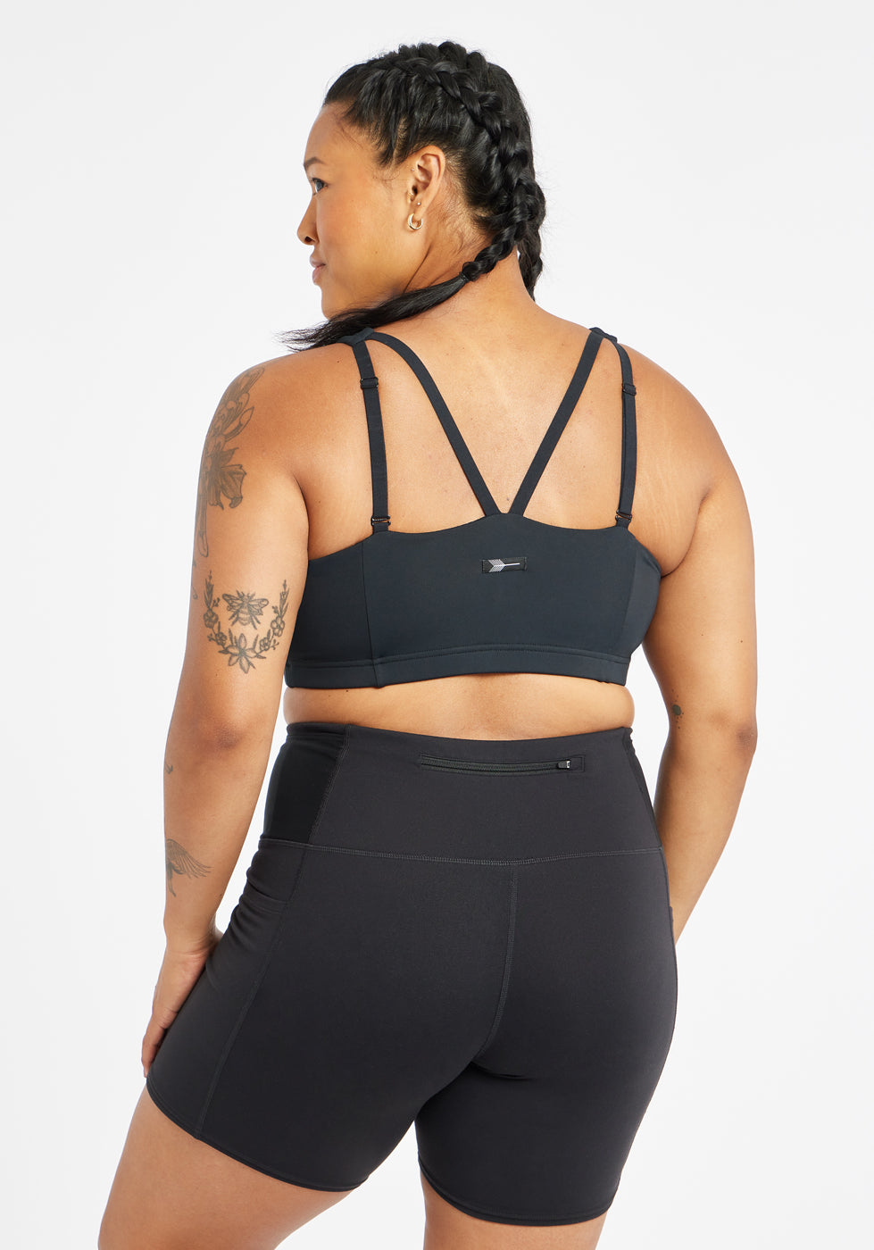 Woman wearing black sports bra in size 12, back view