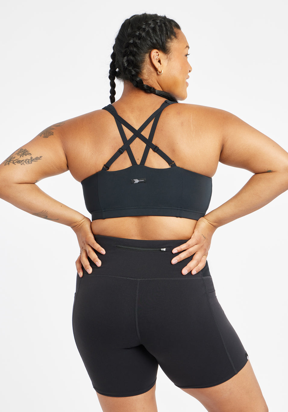 Woman wearing black sports bra in size 12, alternate back view