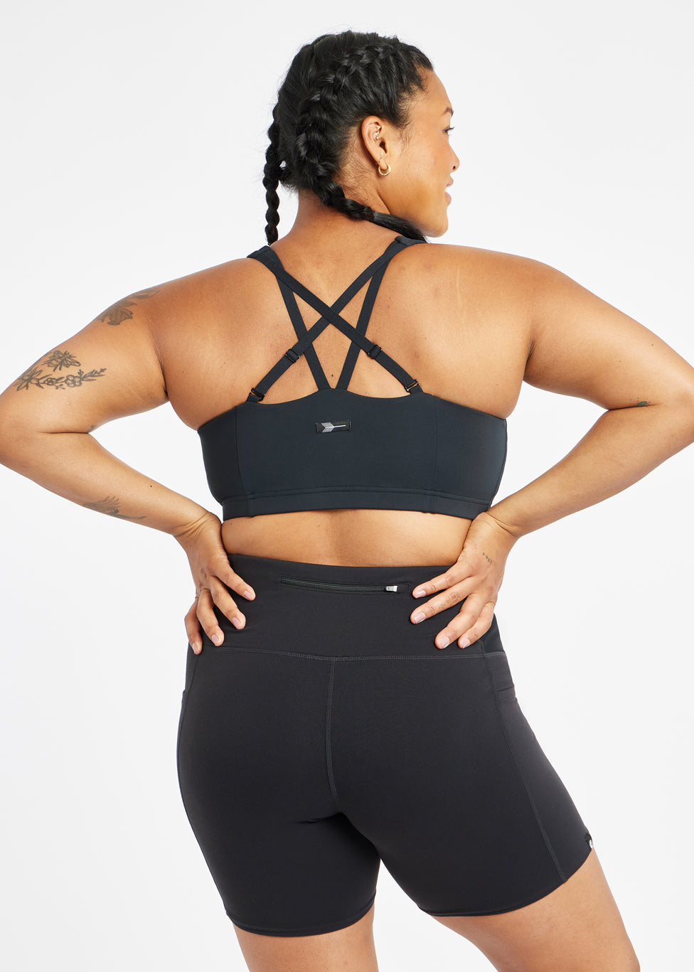 Woman wearing black sports bra in size 12, alternate back view