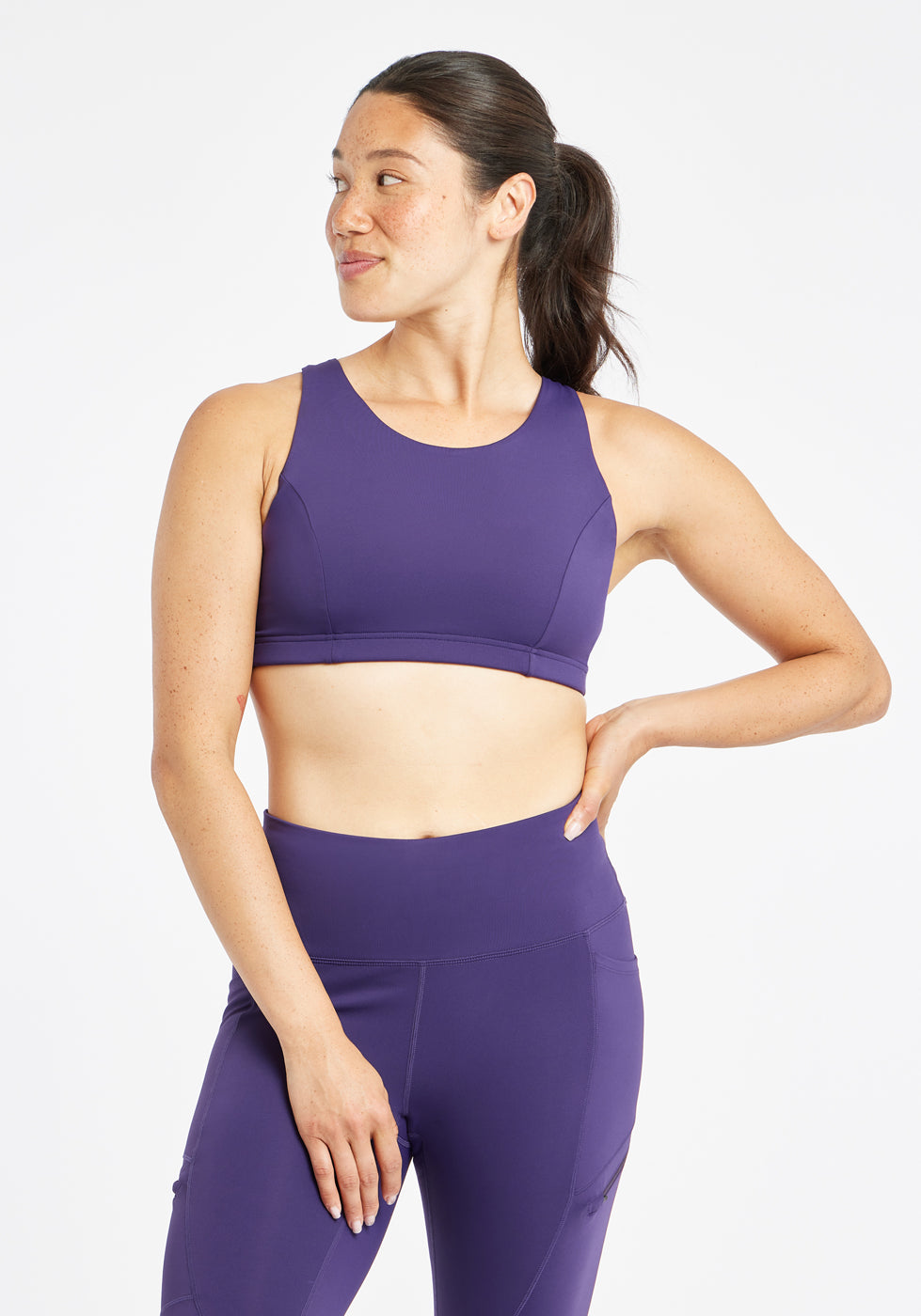 Woman wearing purple sports bra in size 6, front view