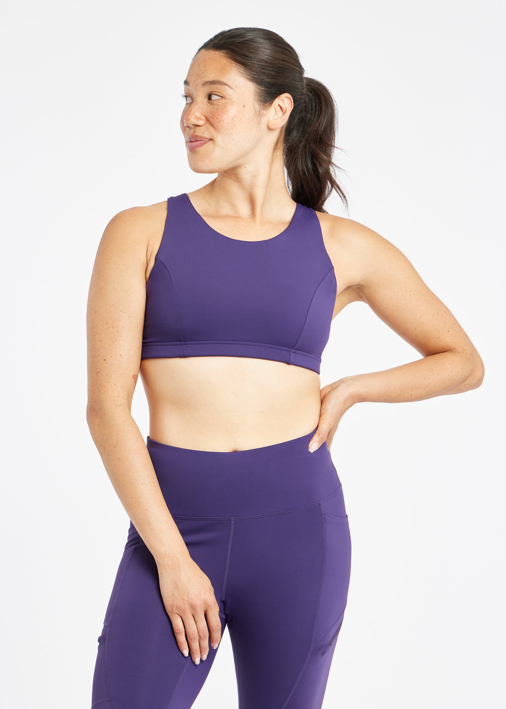 Woman wearing purple sports bra in size 6, front view