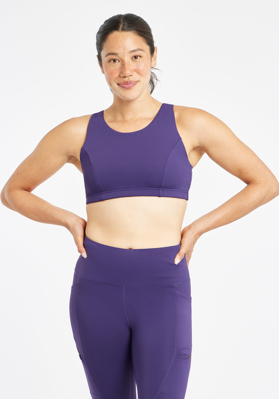 Woman wearing purple sports bra in size 6, alternate front view