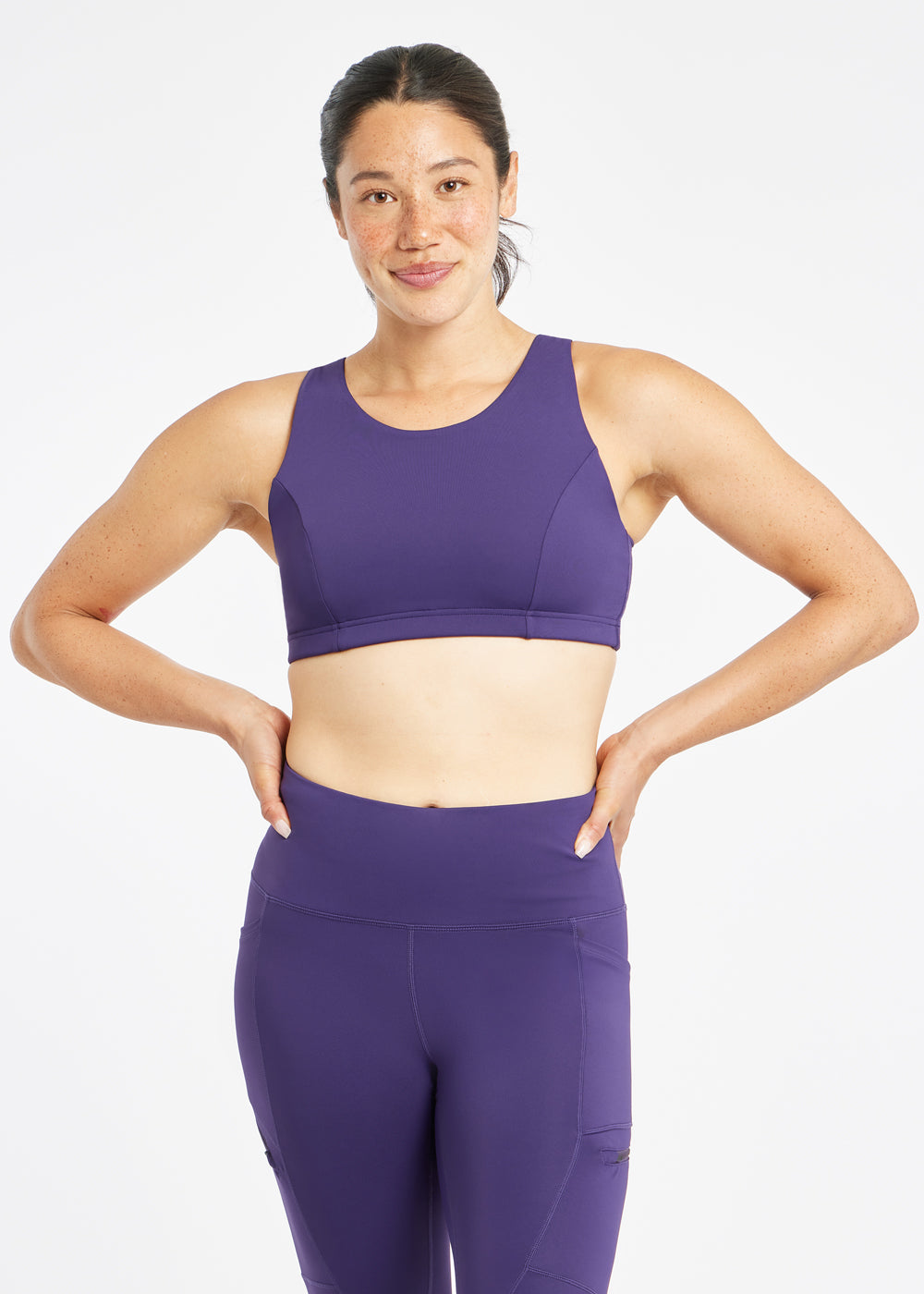 Woman wearing purple sports bra in size 6, alternate front view