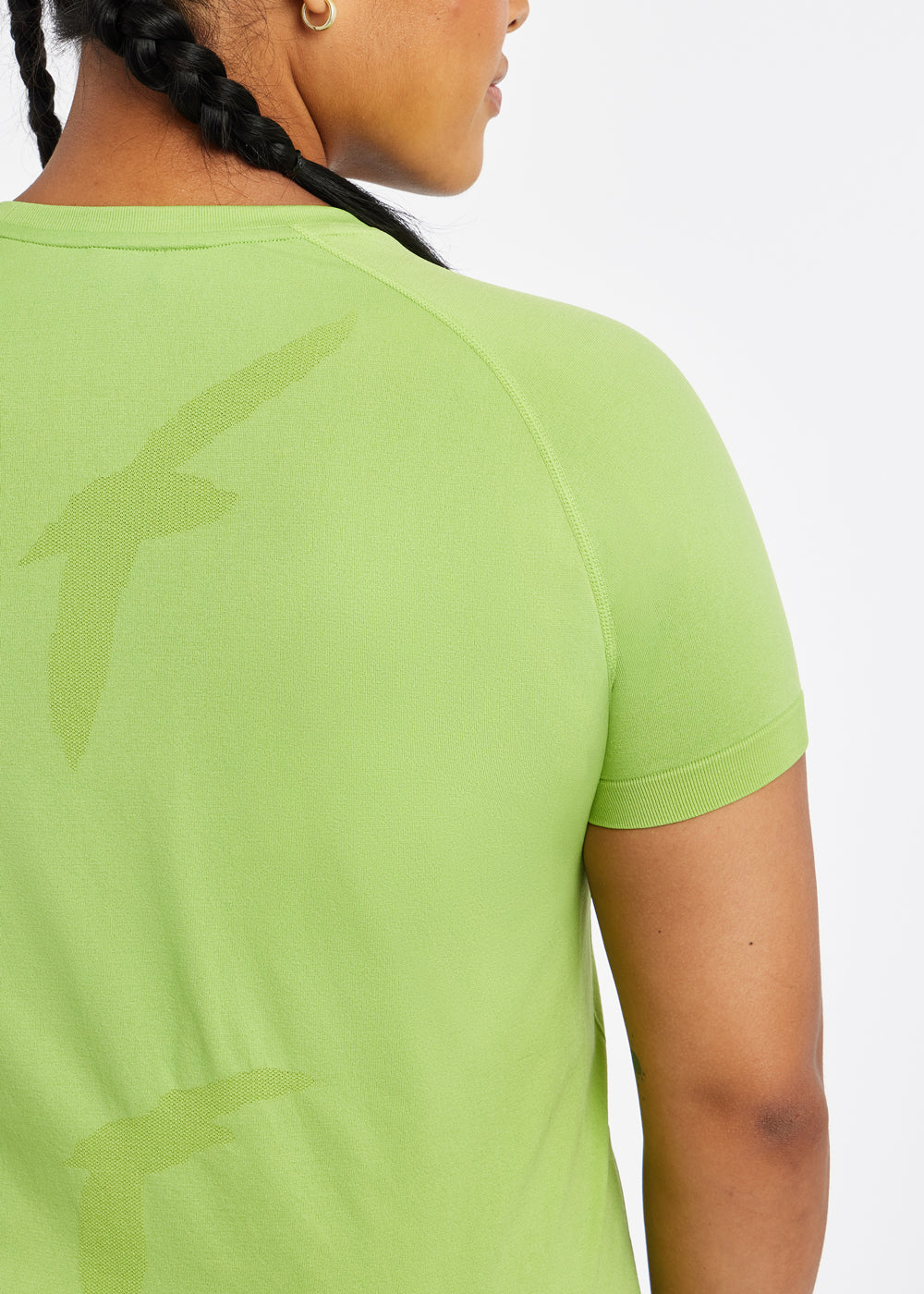 Woman wearing a green running short sleeve, close up of bird details on shirt