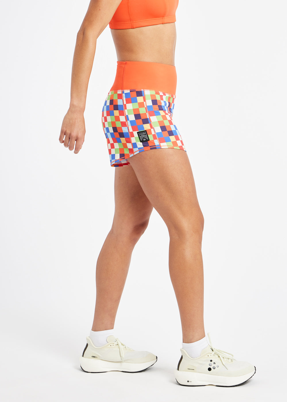 High Rise Roga 4" Running Shorts in colorful checkered print with orange waistband, side view