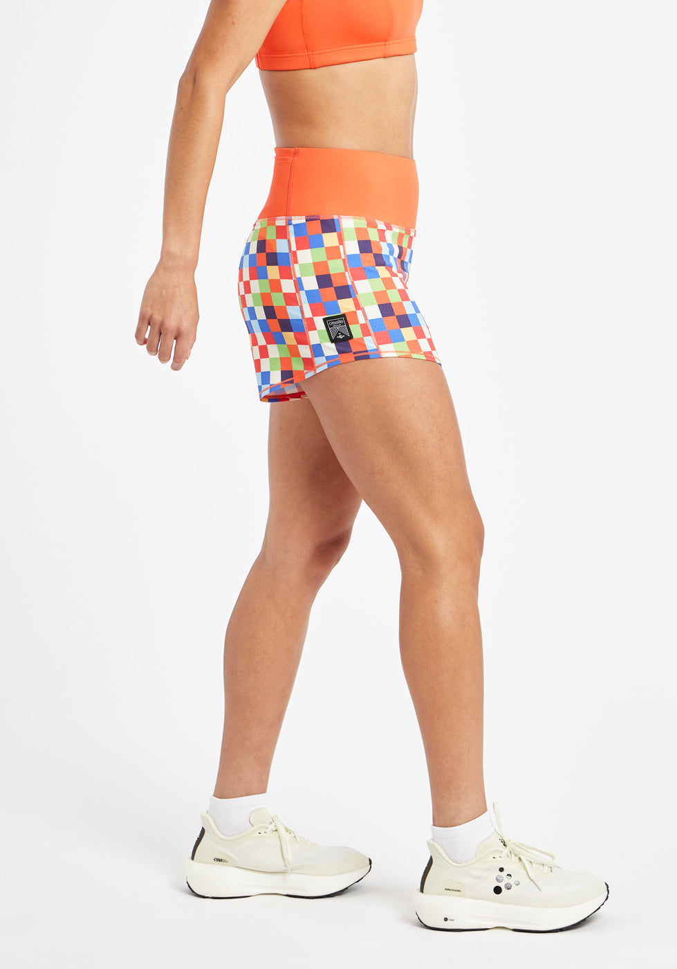 High Rise Roga 4" Running Shorts in colorful checkered print with orange waistband, side view