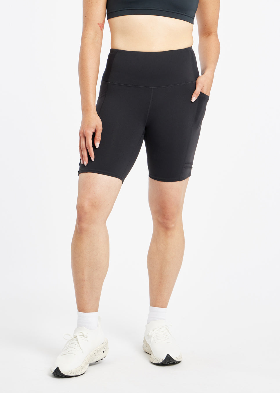 Woman wearing black compression shorts in size 4, front view