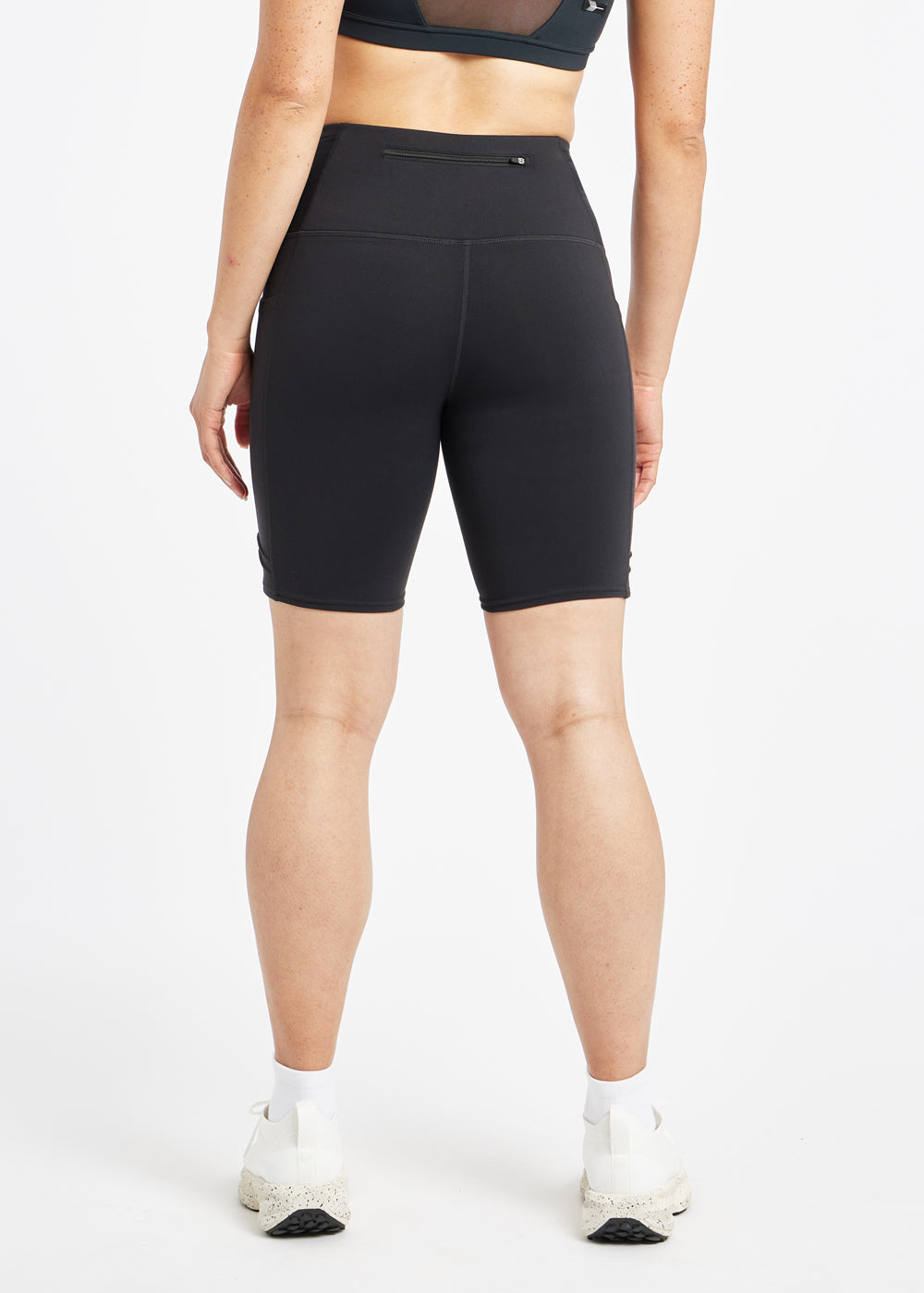 Woman wearing black compression shorts in size 4, back view