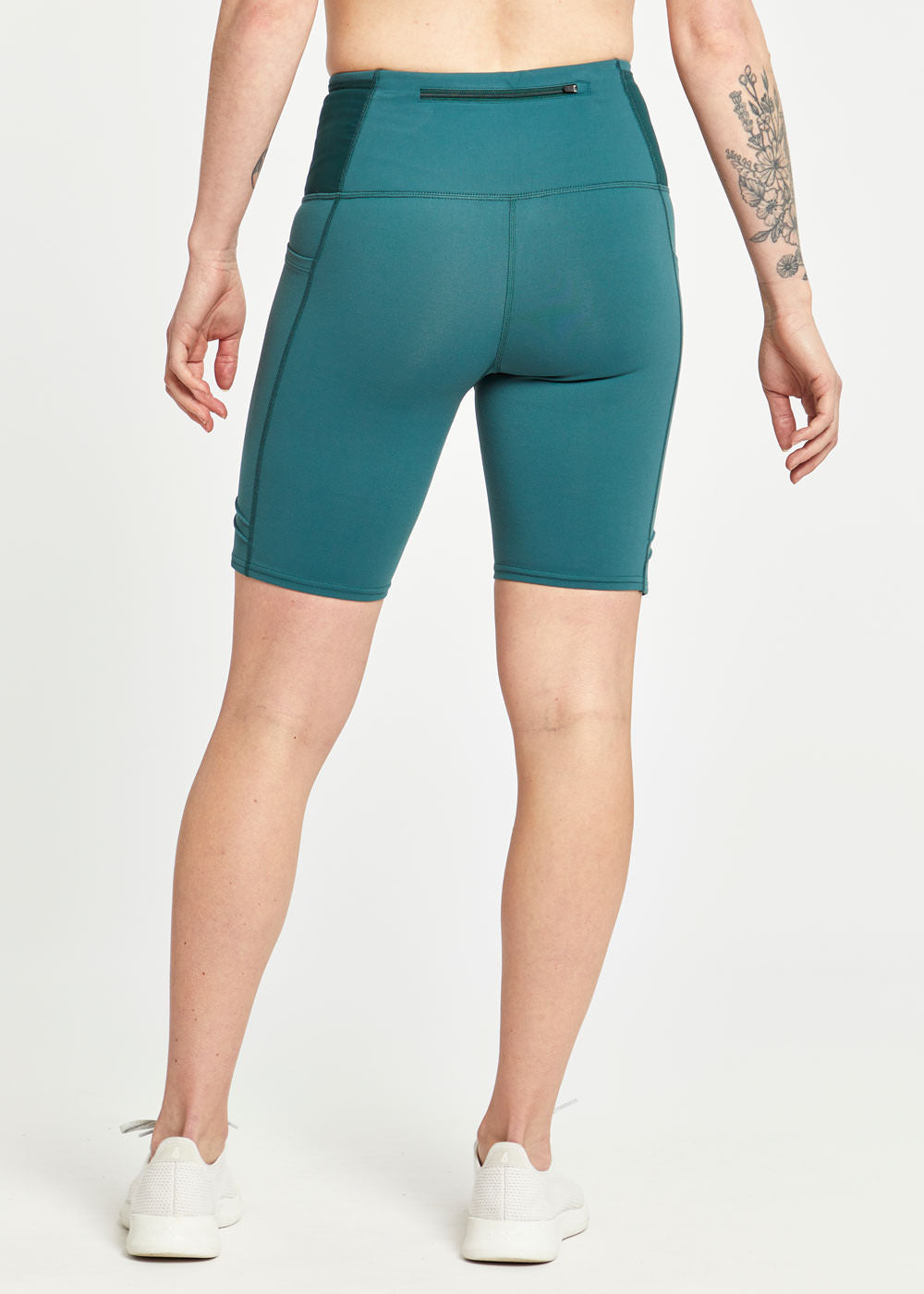 Woman wearing green compression shorts in size 4, back view