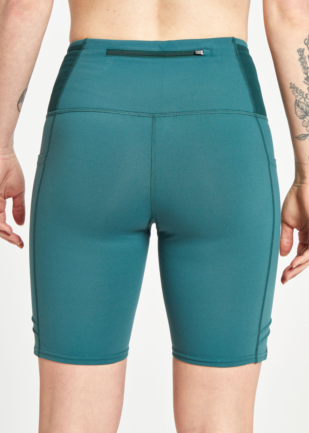 Woman wearing green compression shorts, close up of zipper pocket