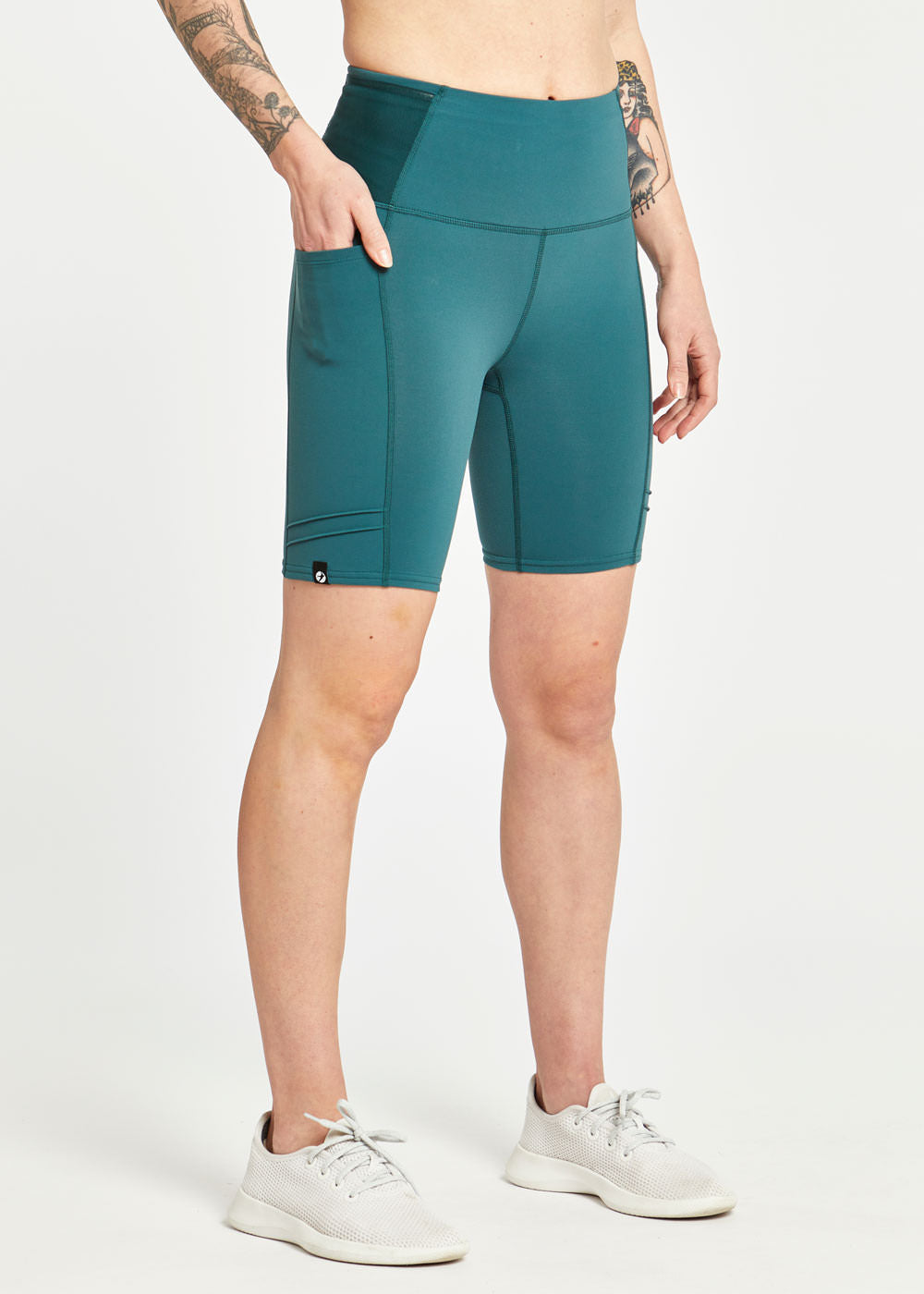 Woman wearing green compression shorts in size 4, front view