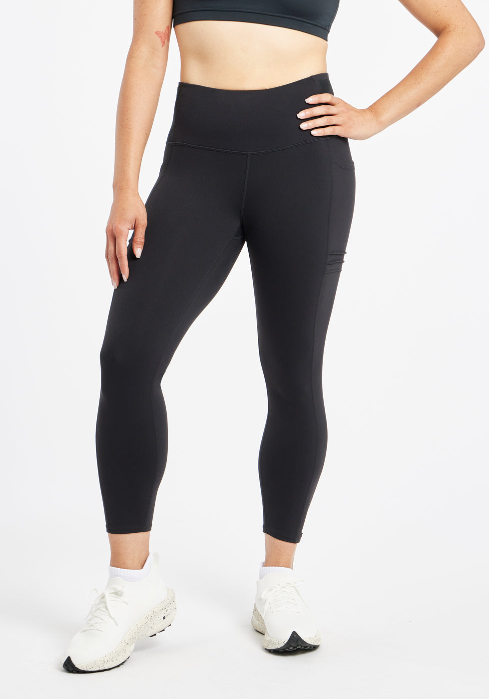 Woman wearing black compression tights in size 4, front view