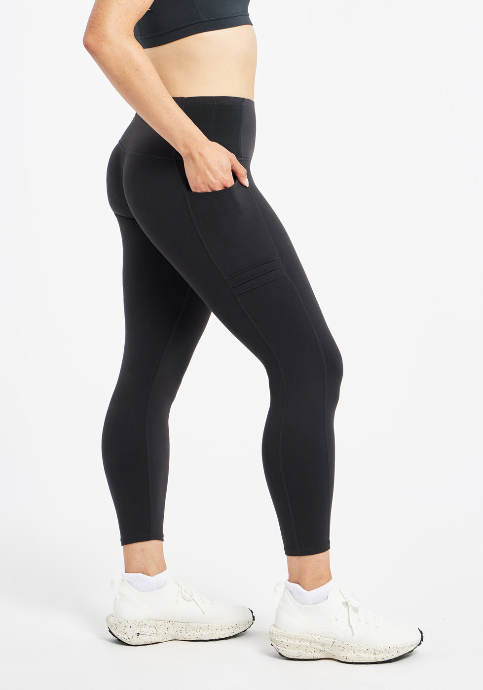 Woman wearing black compression tights in size 4, side view