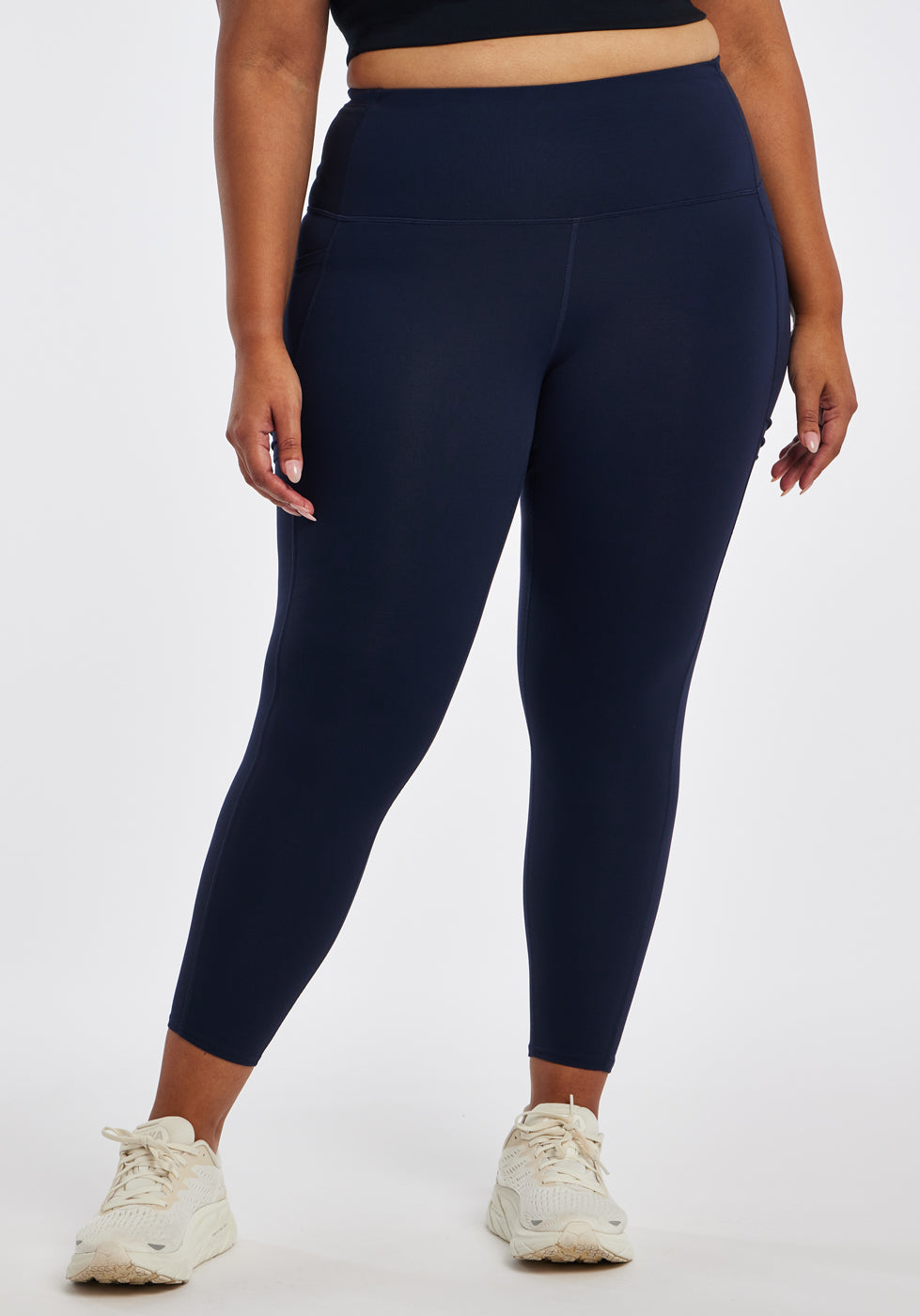 Woman wearing dark blue compression tights in size 16/18, front view