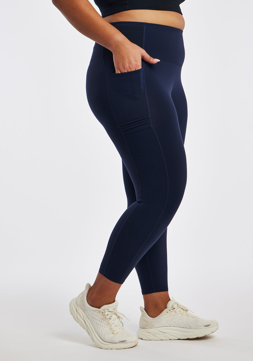 Woman wearing dark blue compression tights in size 16/18, side view
