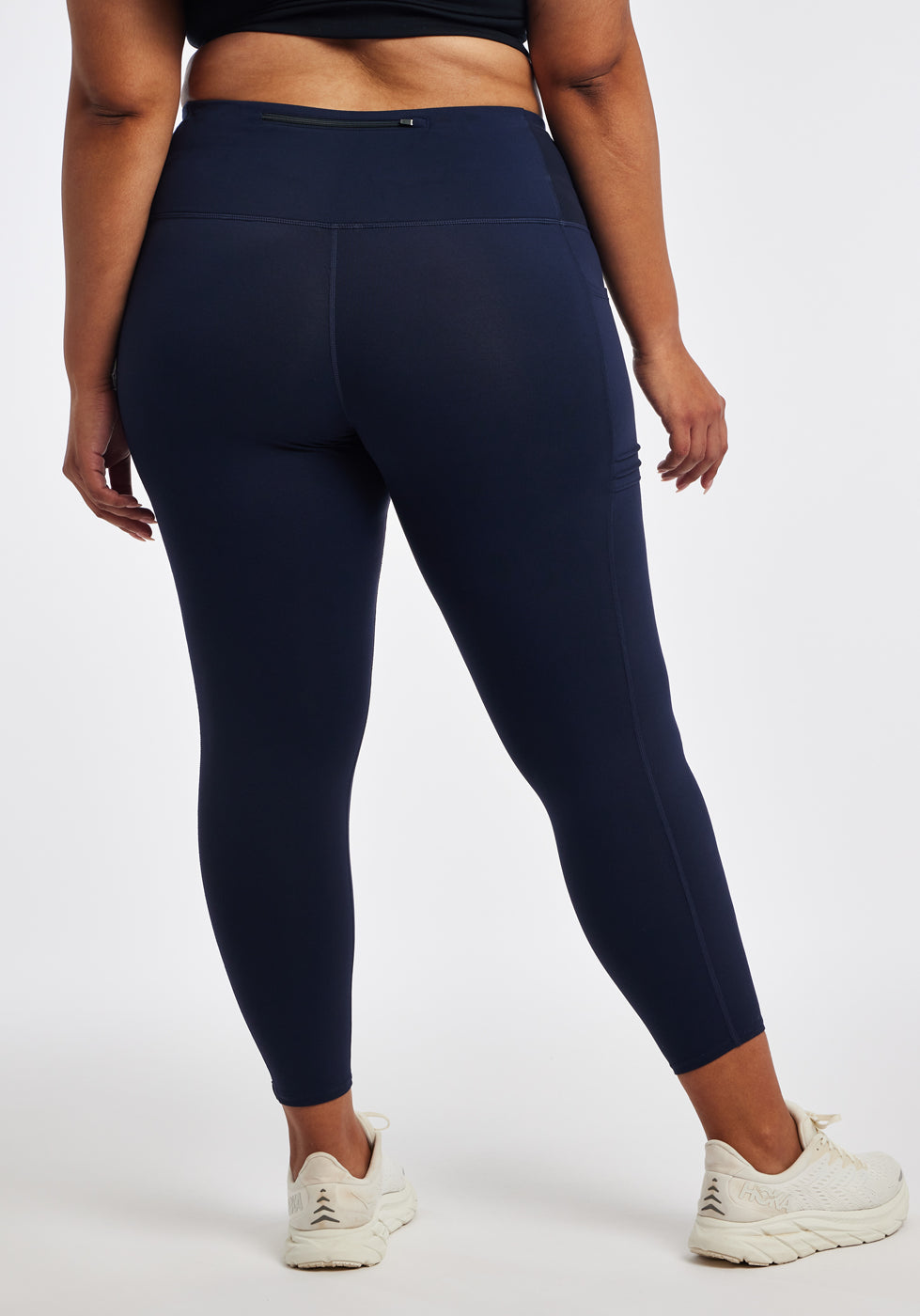 Woman wearing dark blue compression tights in size 16/18, back view