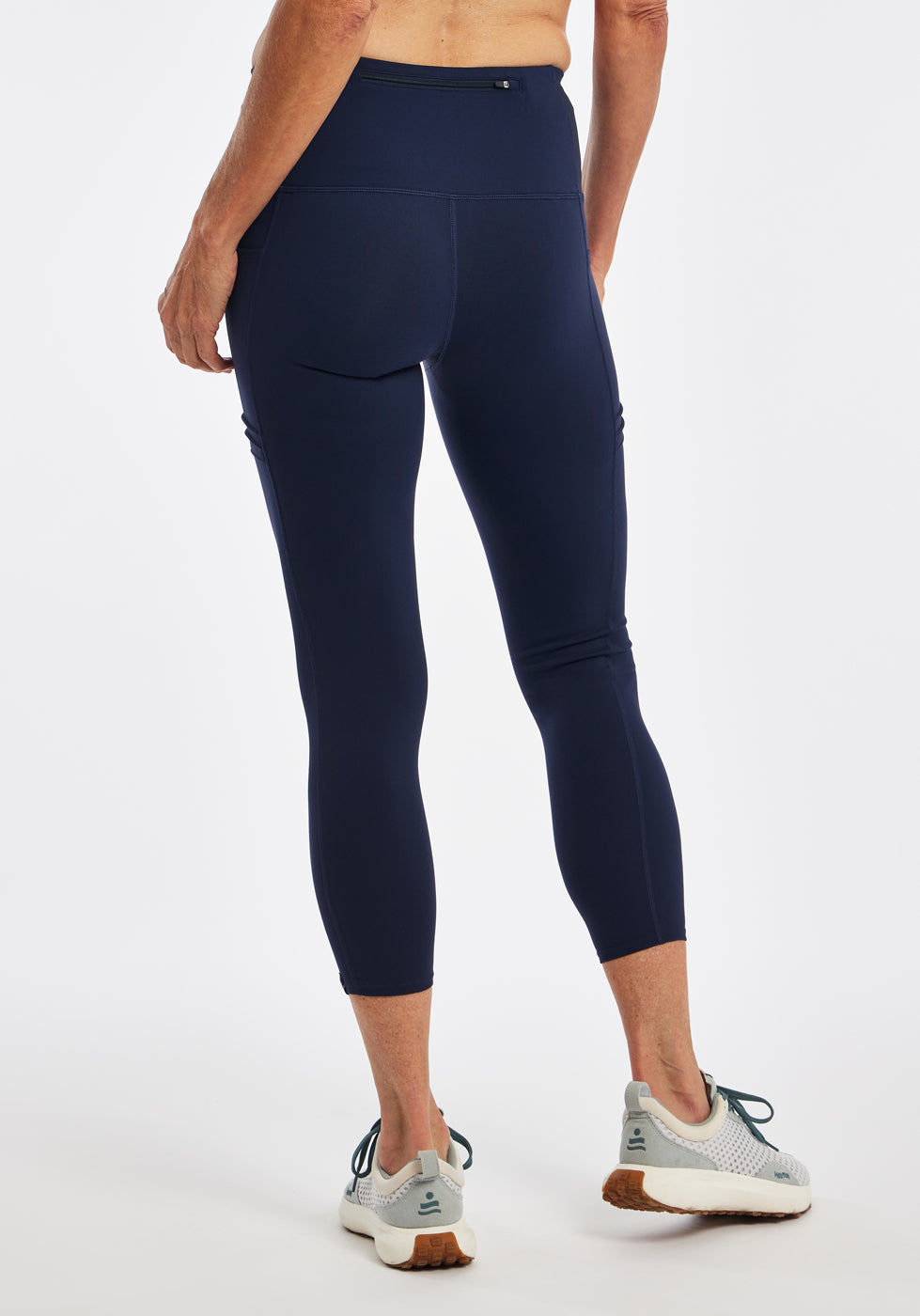 Woman wearing dark blue compression tights in size 4, back view