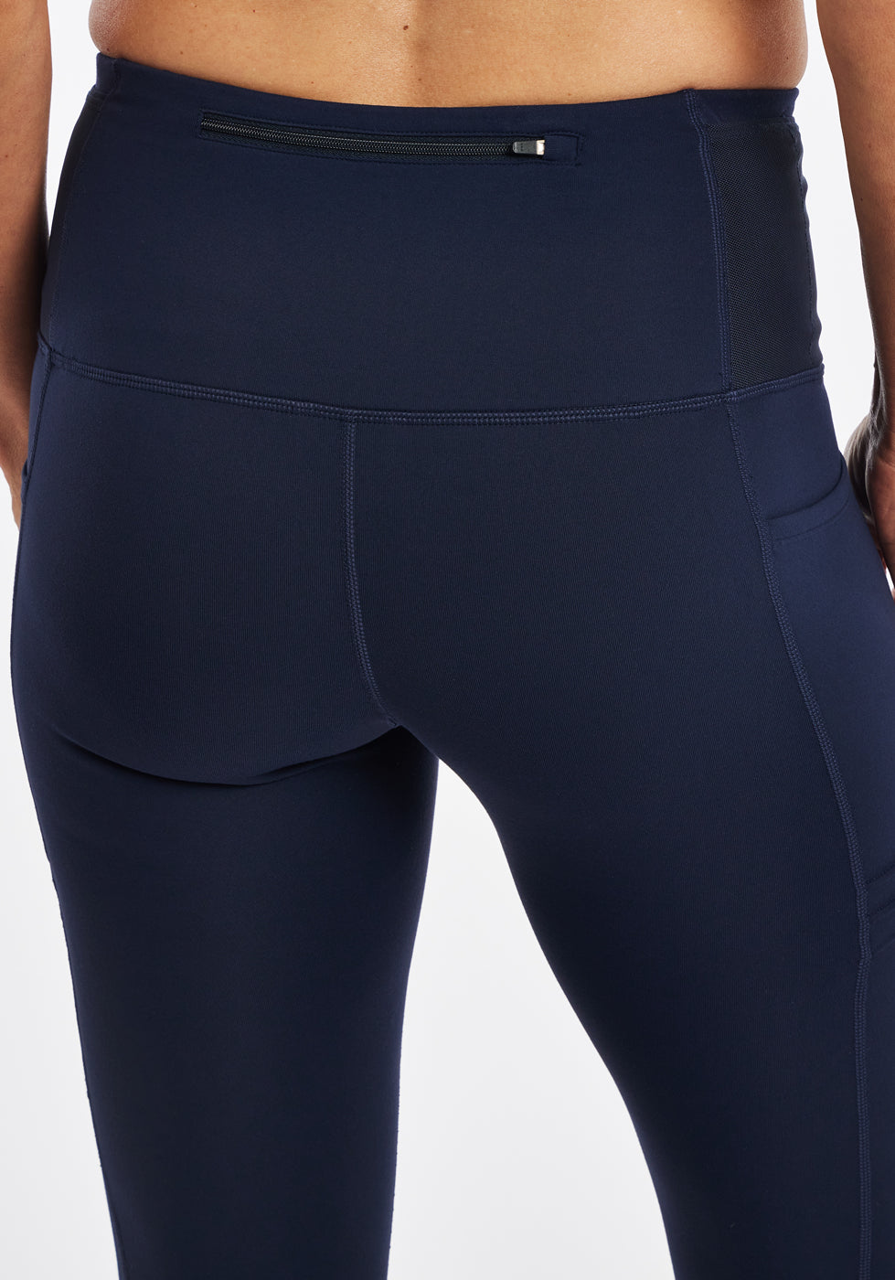 Woman wearing dark blue compression tights, close up back zipper pocket