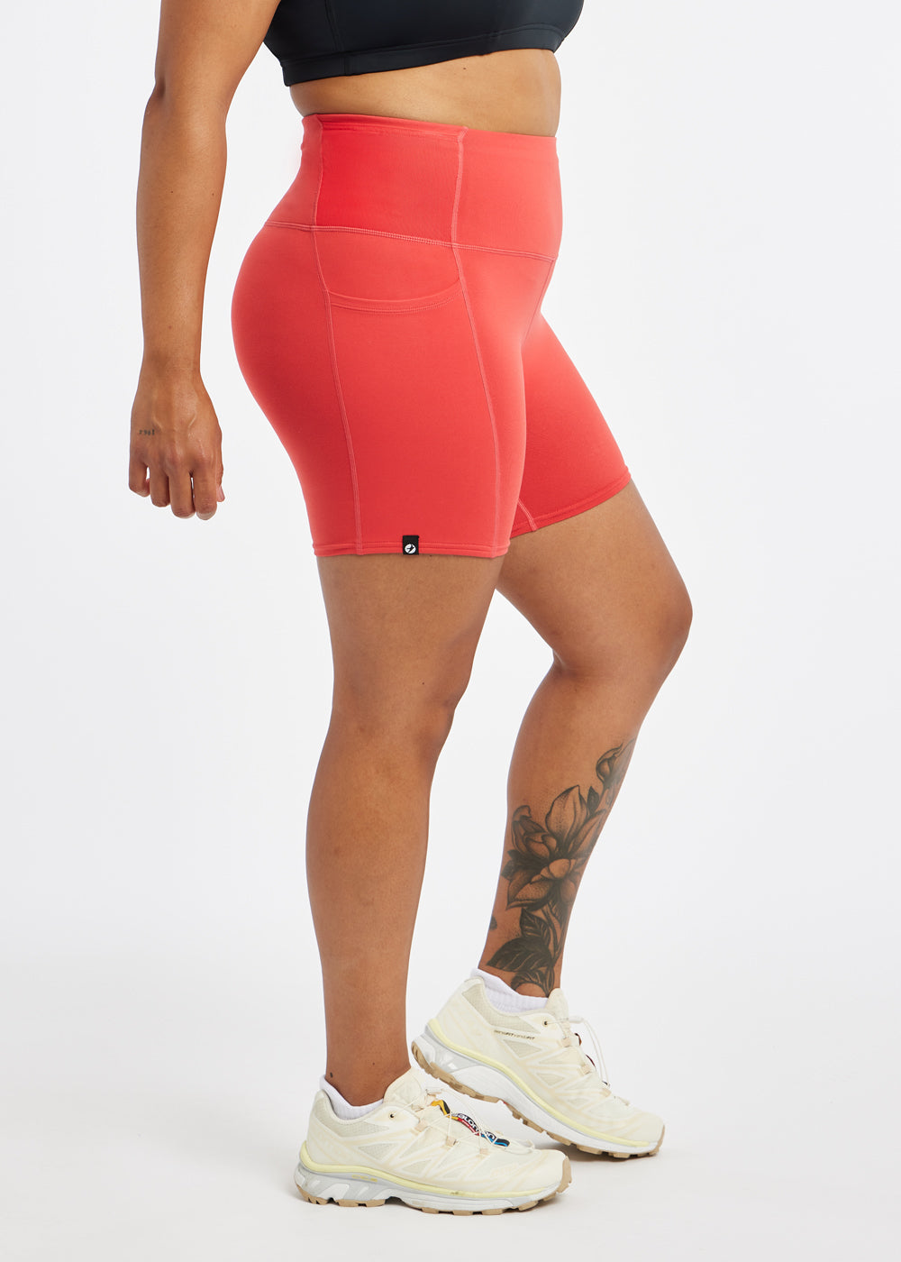 Woman wearing red orange compression shorts in size 12, side view