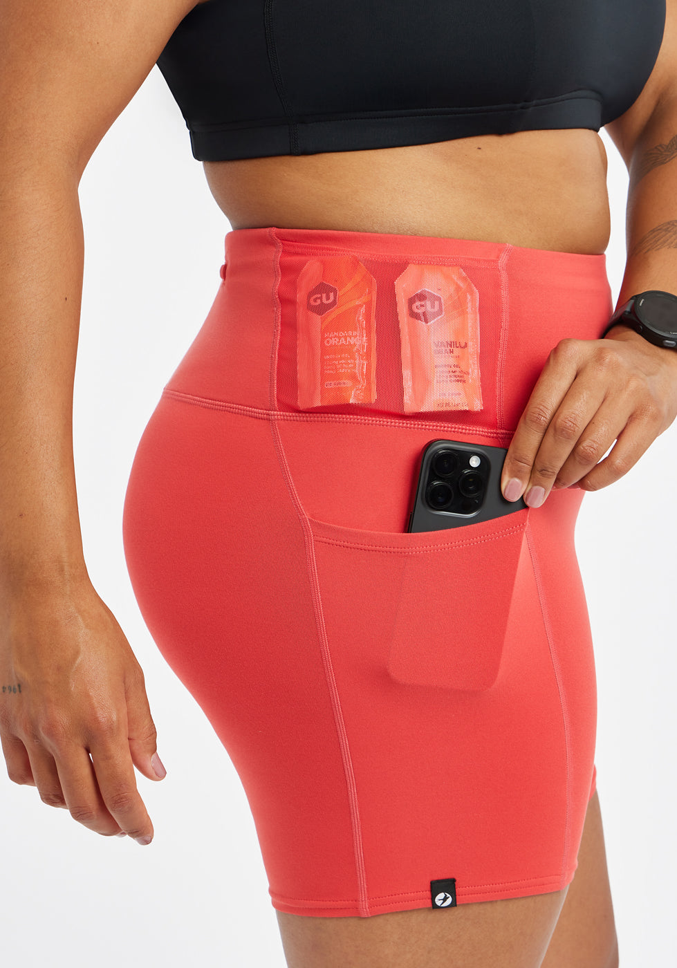 Woman wearing red orange compression shorts, close up of side pockets