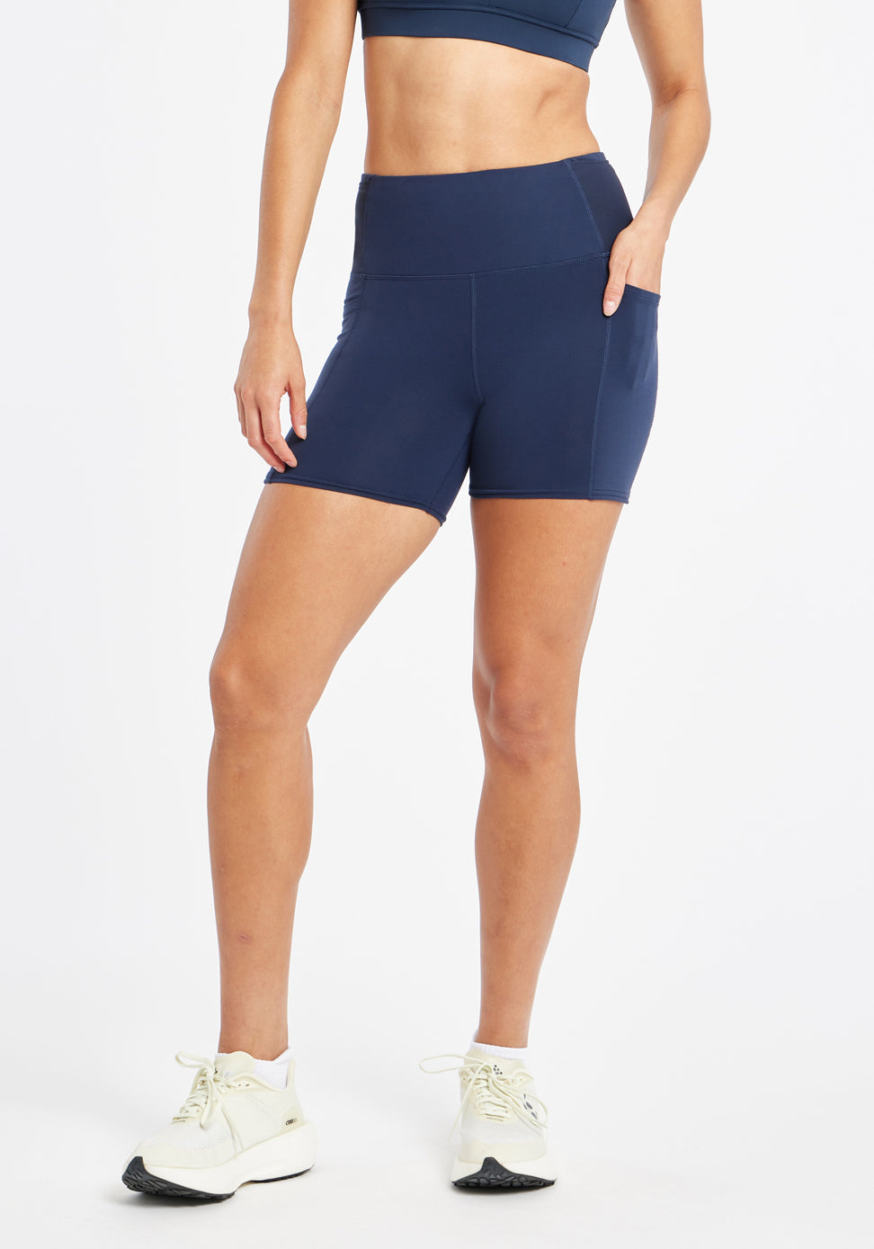 Woman wearing dark blue compression shorts in size 6, alternate front view