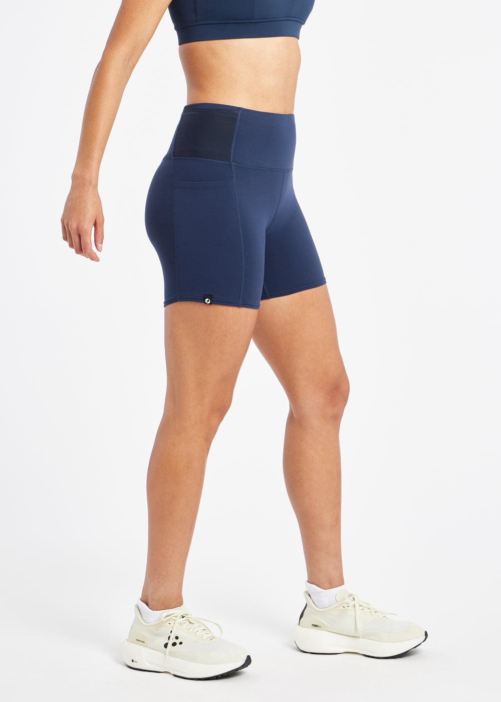 Woman wearing dark blue compression shorts in size 6, side view