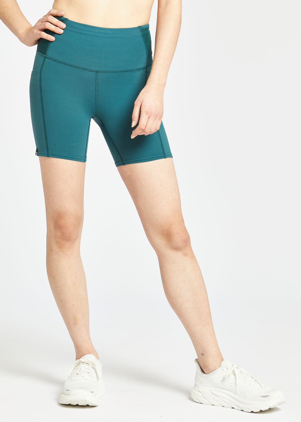 Woman wearing green compression shorts in size 4, front view