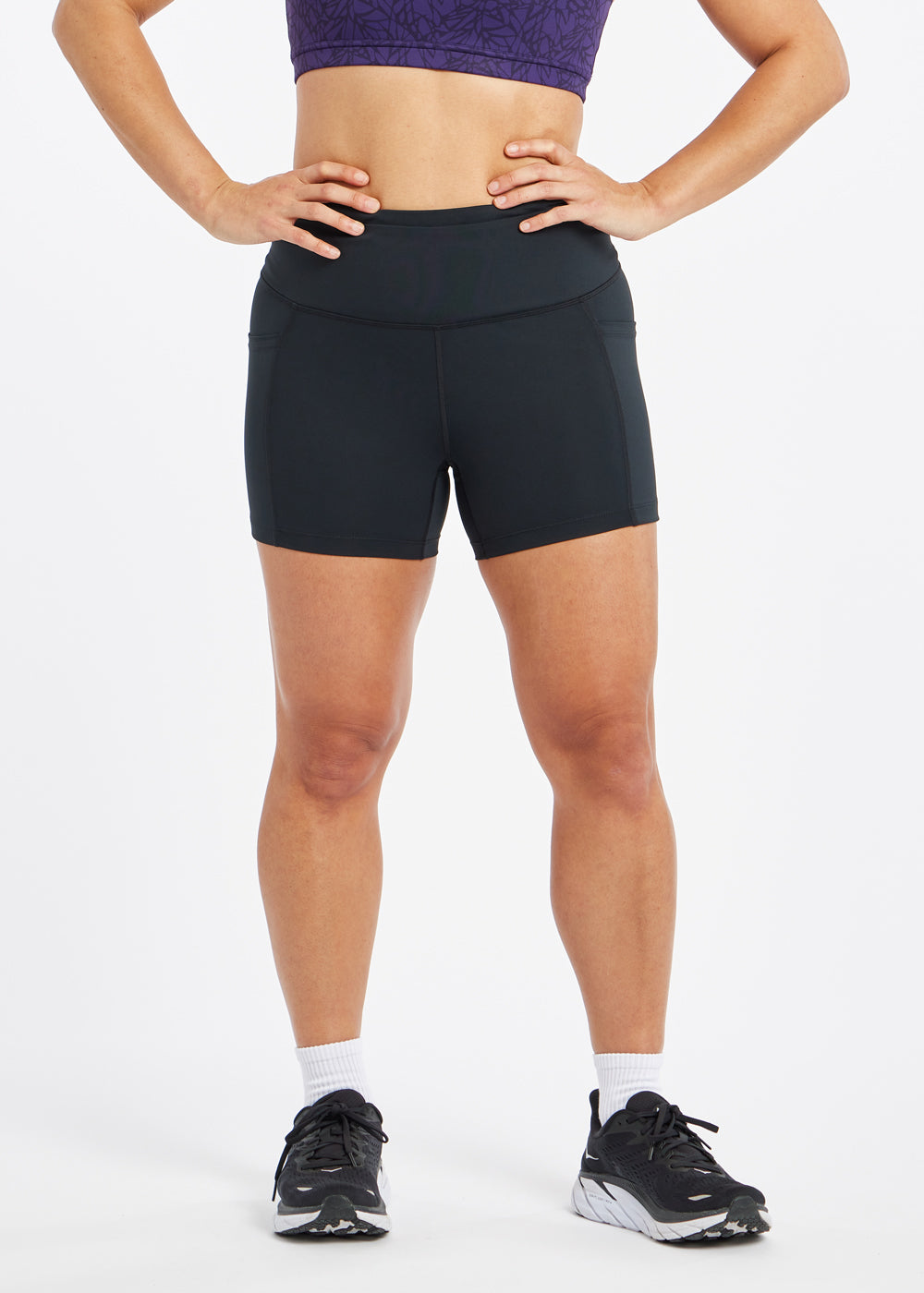 Woman wearing black compression shorts in size 6, front view