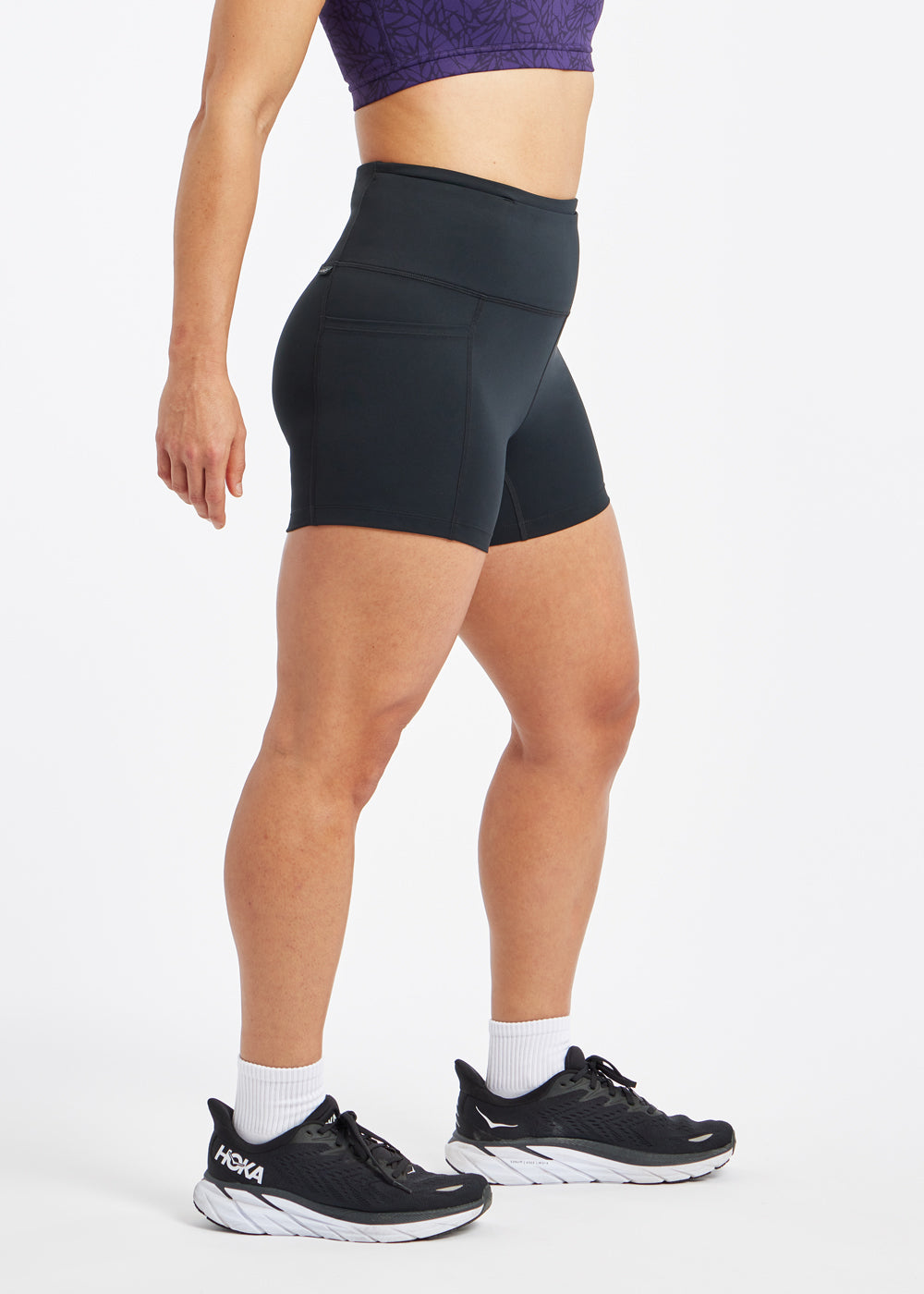 Woman wearing black compression shorts in size 6, side view