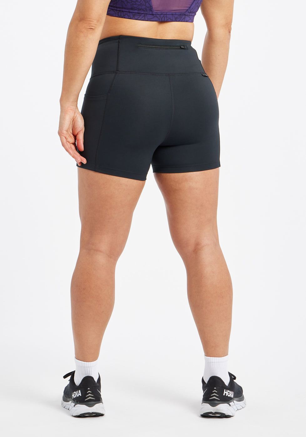 Woman wearing black compression shorts in size 6, back view