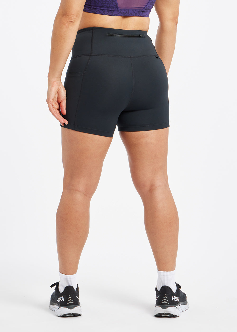 Woman wearing black compression shorts in size 6, back view