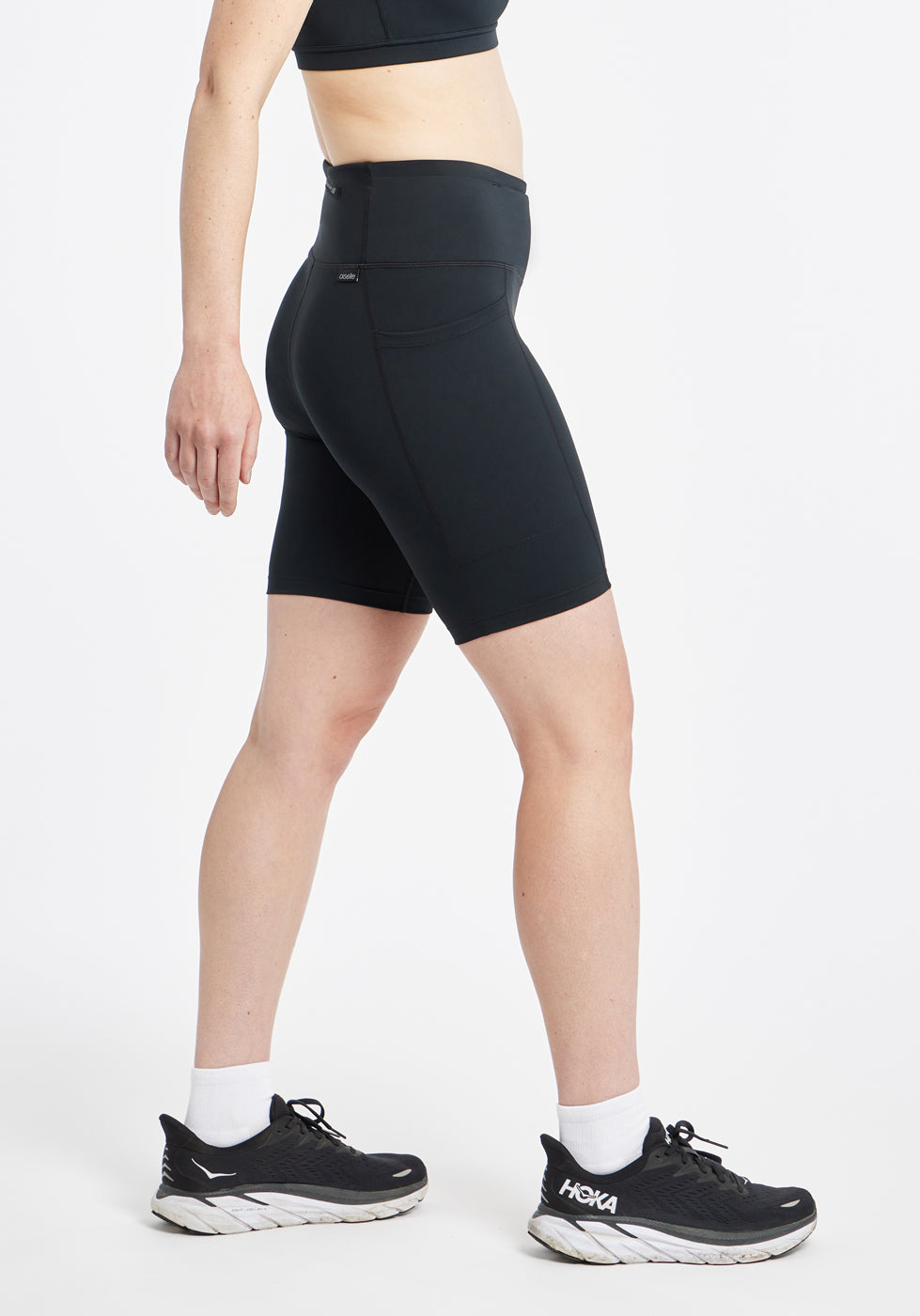 Woman wearing black compression shorts in size 6, side view