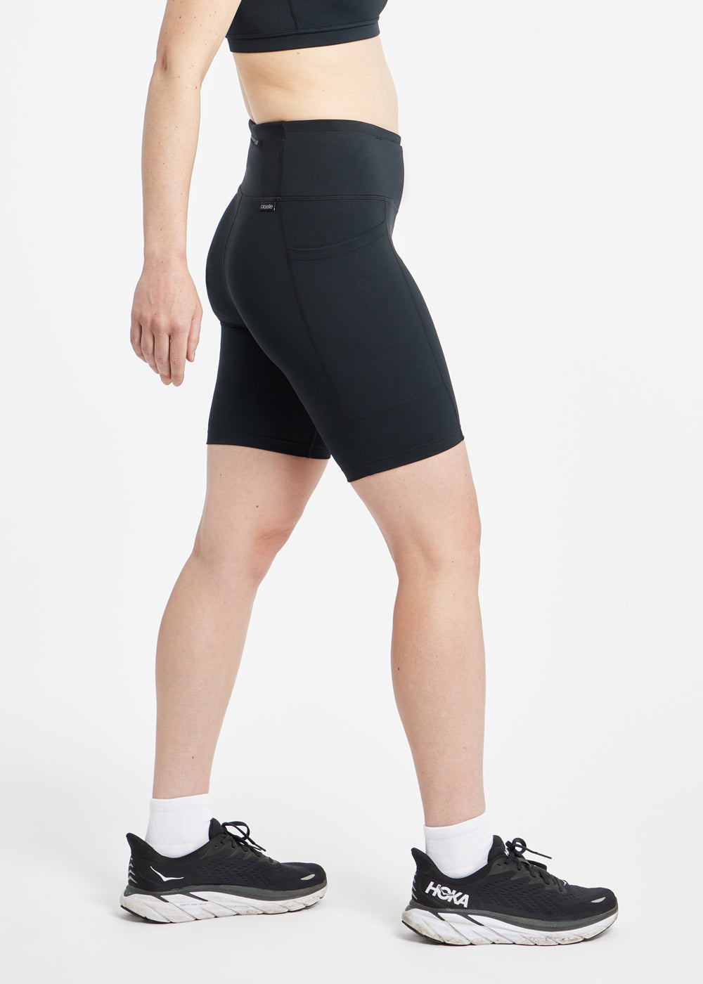 Woman wearing black compression shorts in size 6, side view