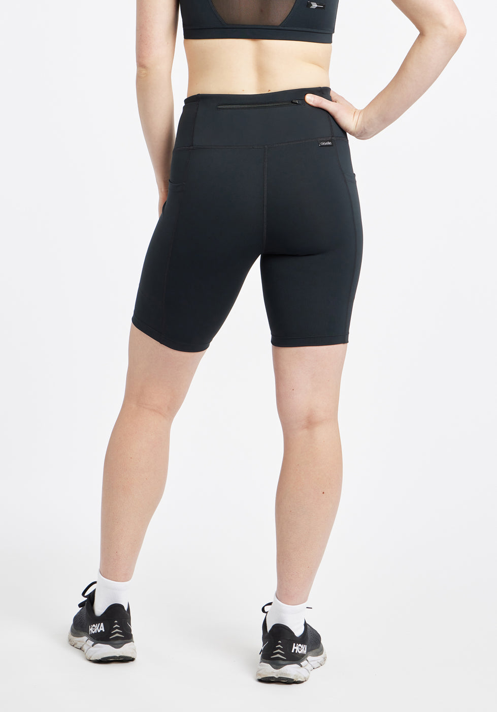 Woman wearing black compression shorts in size 6, back view