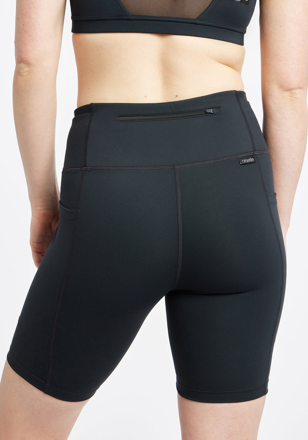 Woman wearing black compression shorts, close up of back zipper pocket