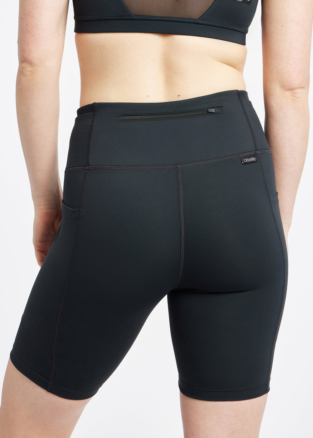 Woman wearing black compression shorts, close up of back zipper pocket