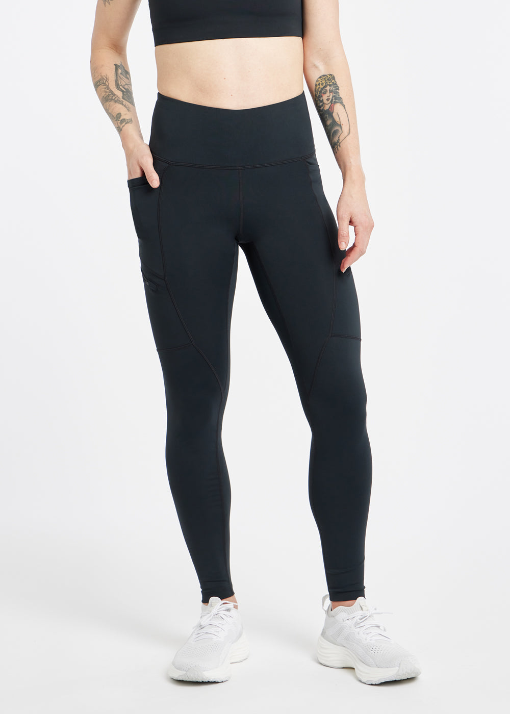 Woman wearing black running tights in size 4, front view