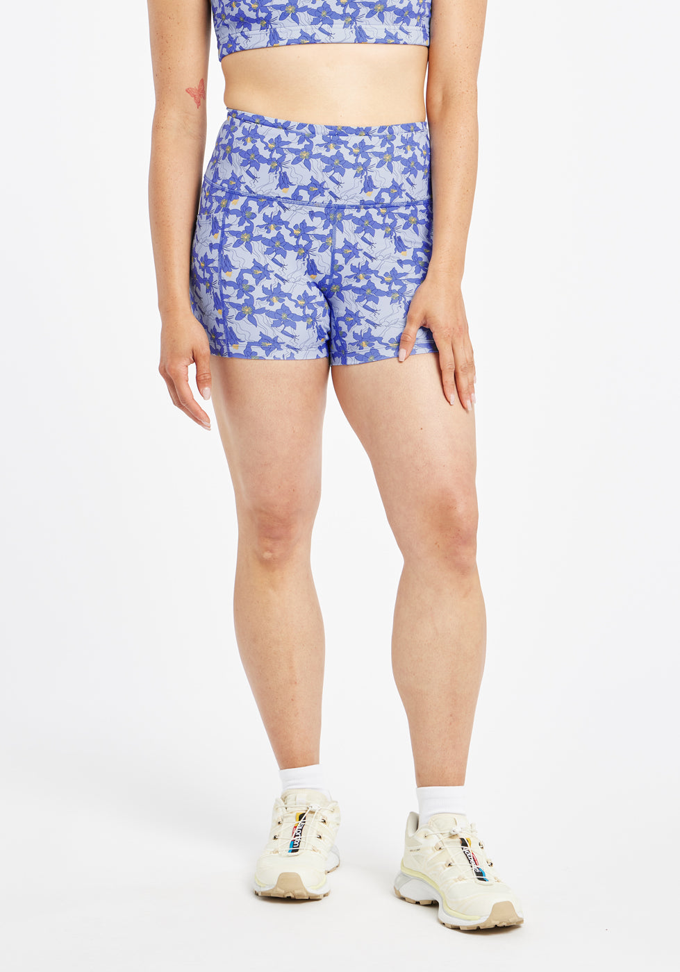 Woman wearing blue with blue flower print compression shorts in size 6, front view