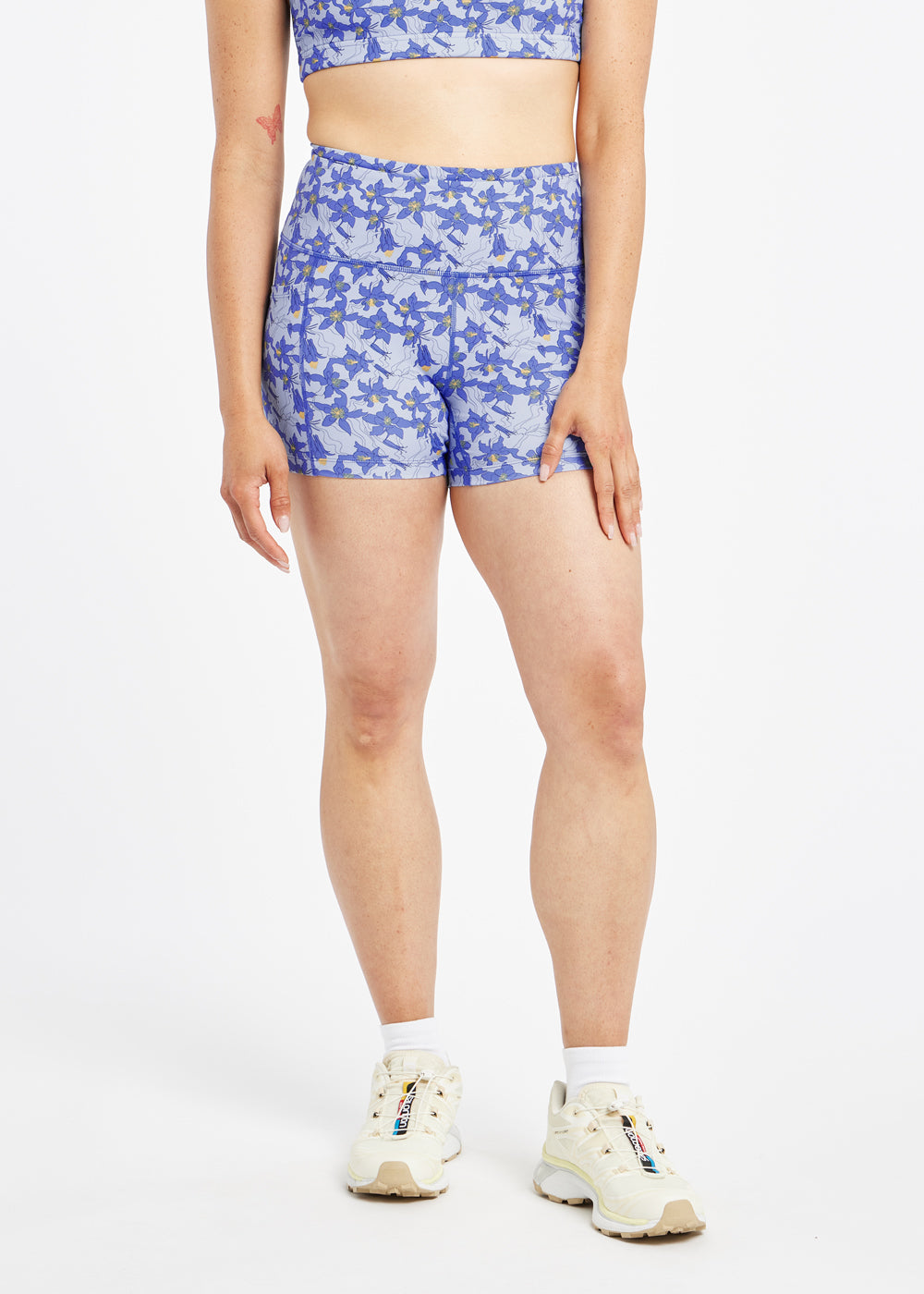 Woman wearing blue with blue flower print compression shorts in size 6, front view