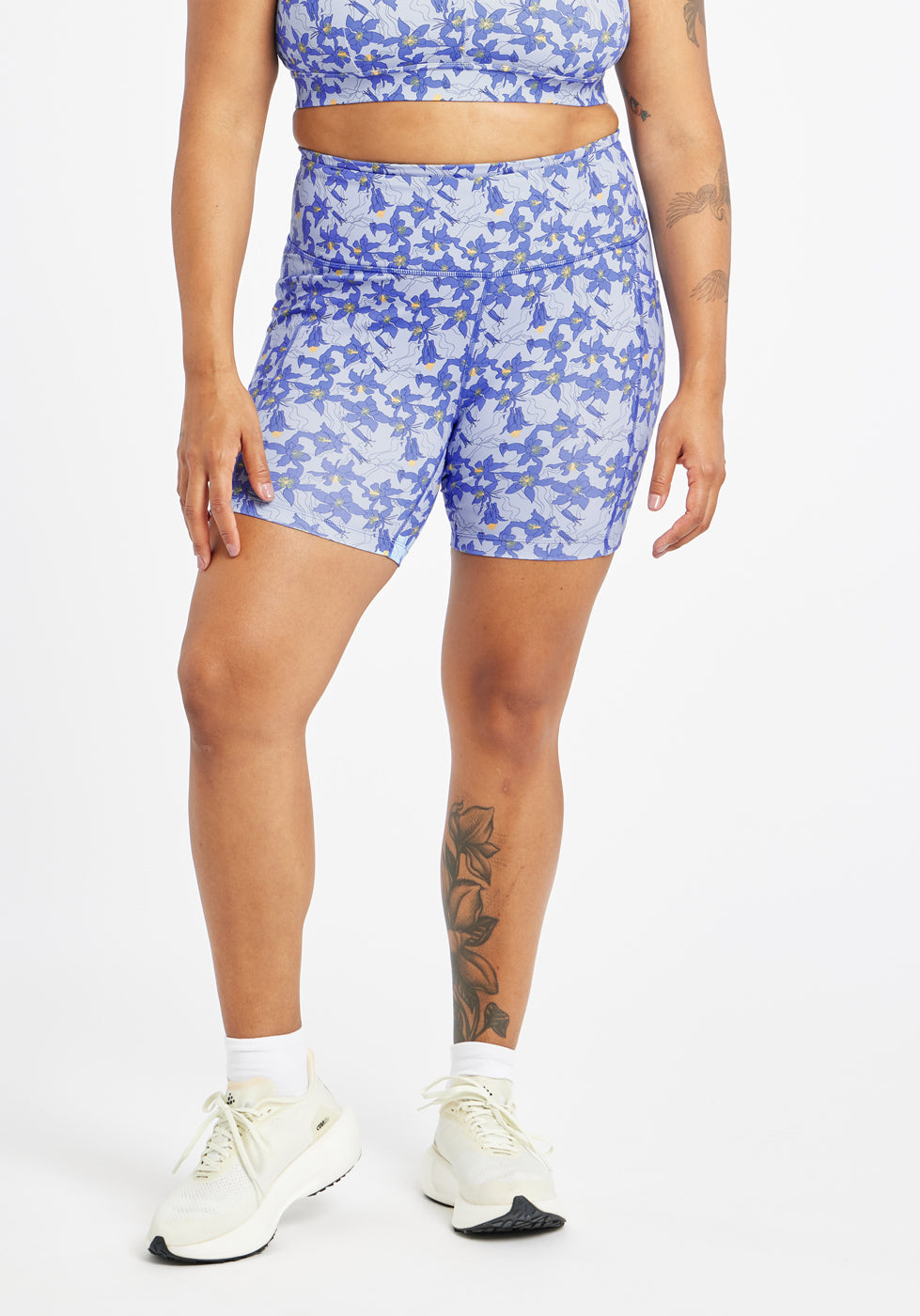 Woman wearing blue with blue floral print compression shorts in size 12, front view