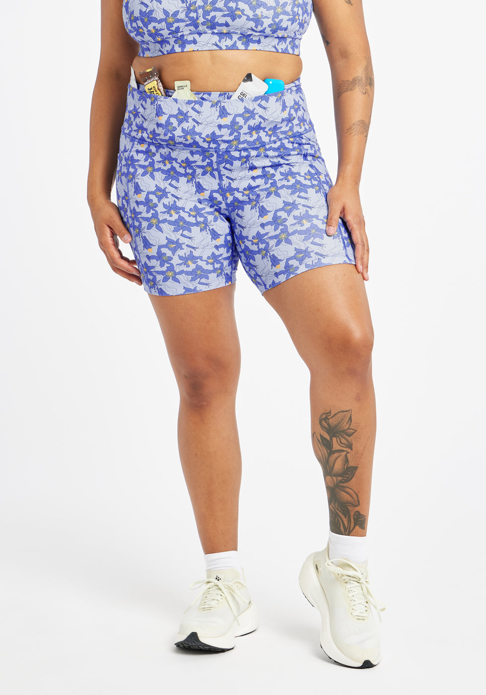 Woman wearing blue with blue floral print compression shorts in size 12, alternate front view