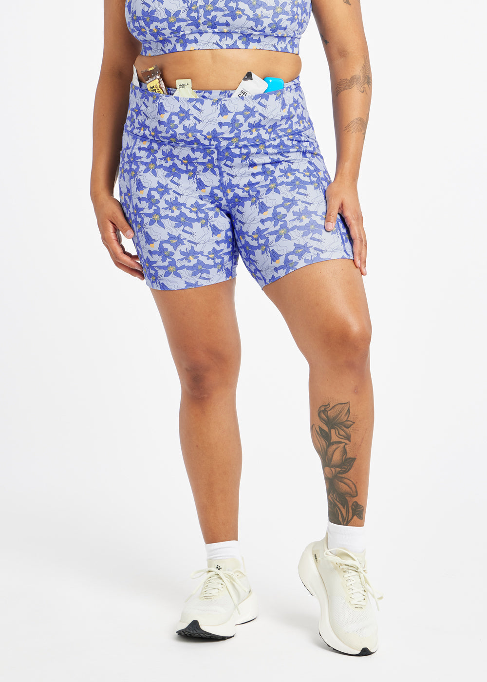 Woman wearing blue with blue floral print compression shorts in size 12, alternate front view