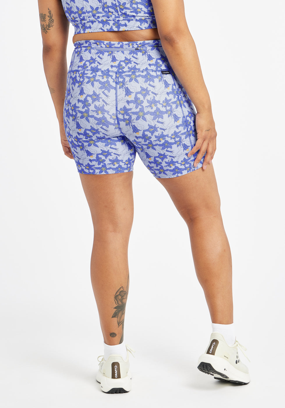 Woman wearing blue with blue floral print compression shorts in size 12, back view