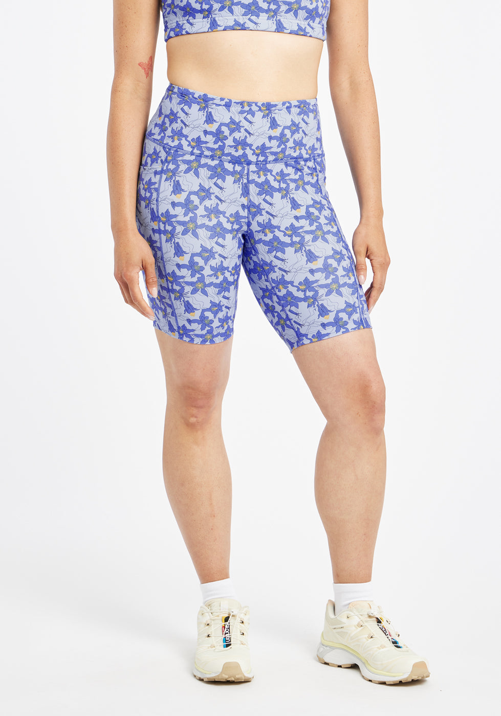 Woman wearing blue with blue floral print compression shorts in size 6, front view