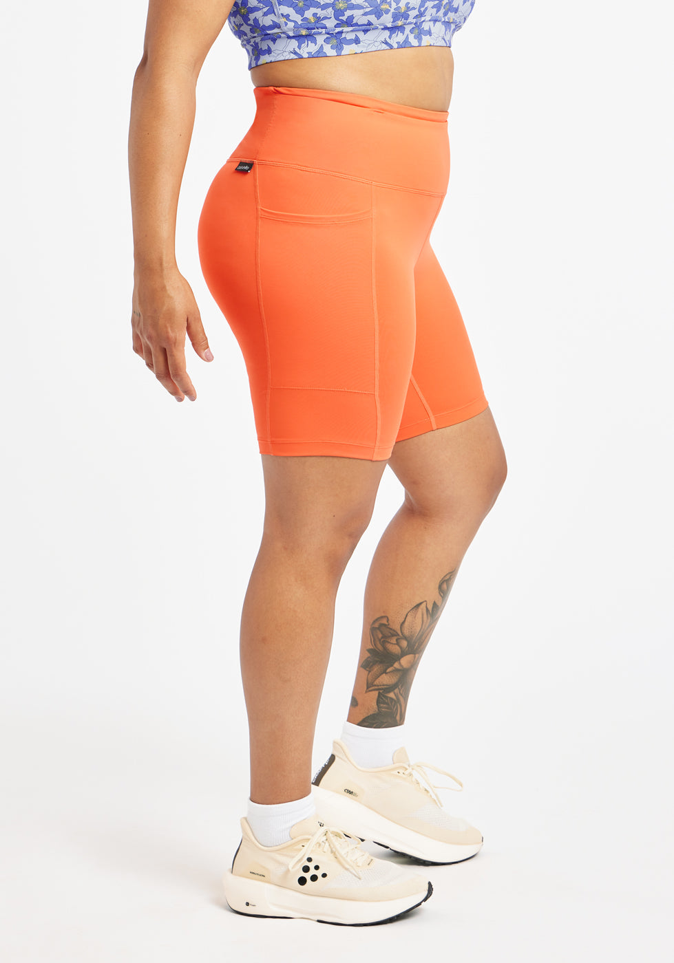 Woman wearing orange compression shorts in size 12, side view